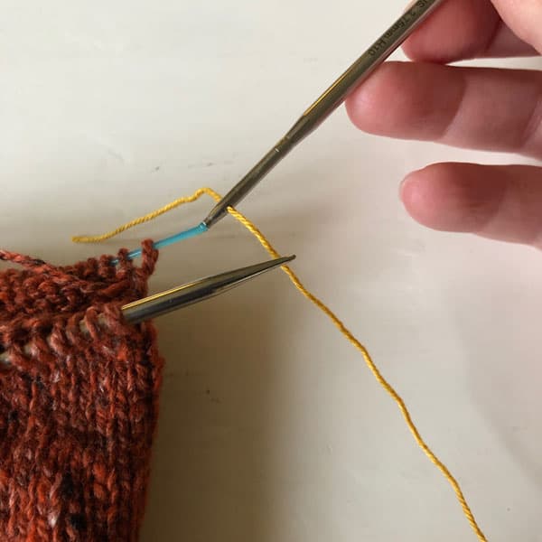 The scrap yarn I'm using for my lifeline is thread through the needle. Use the hole on your HiyaHiya interchangeable Knitting Needles to add a lifeline to your knitting. Easy, simple, genious! #HiyaHiya #Lifeline #Knitting #KnittingHack