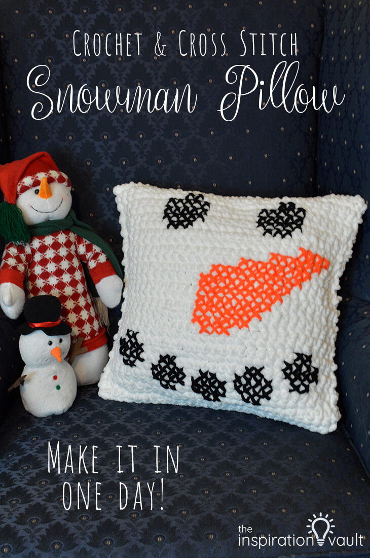 A crochet snowman pillow embellished with cross stitch