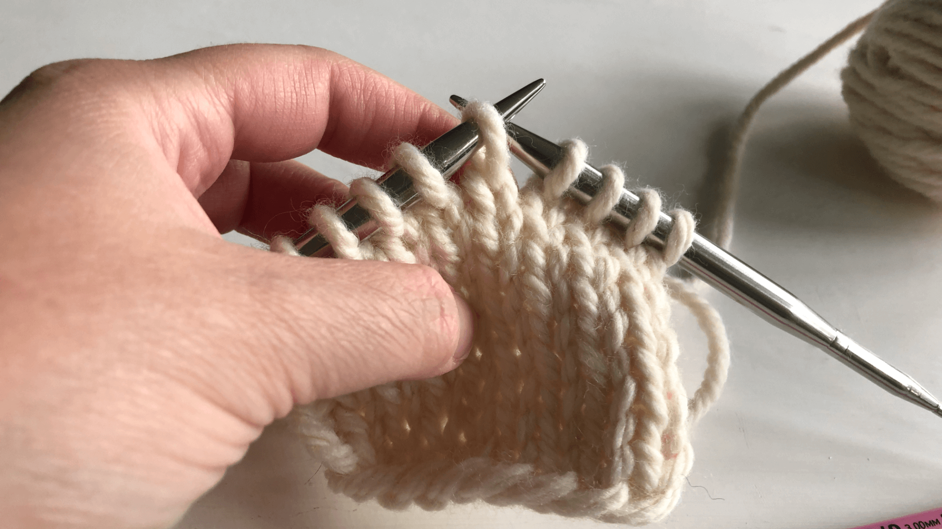 Put the dropped stitch back on the needle with the right leg in front of the needle tip.