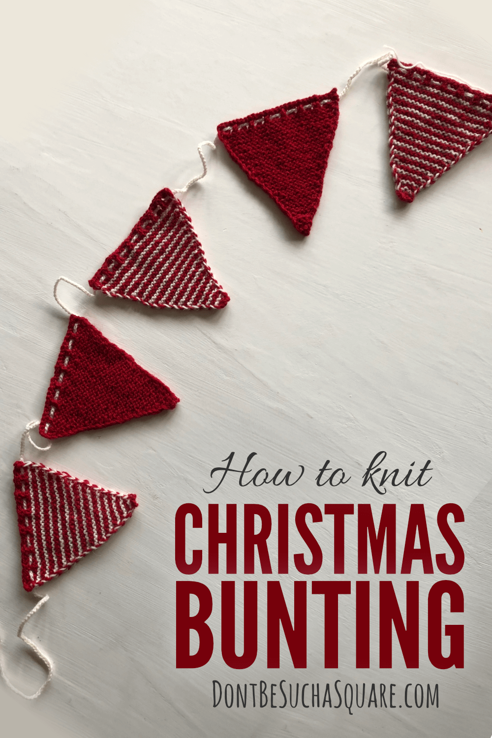 A picture of a knitted red and white bunting laying on a white table. The text overlay says "how to knit a Christmas bunting"