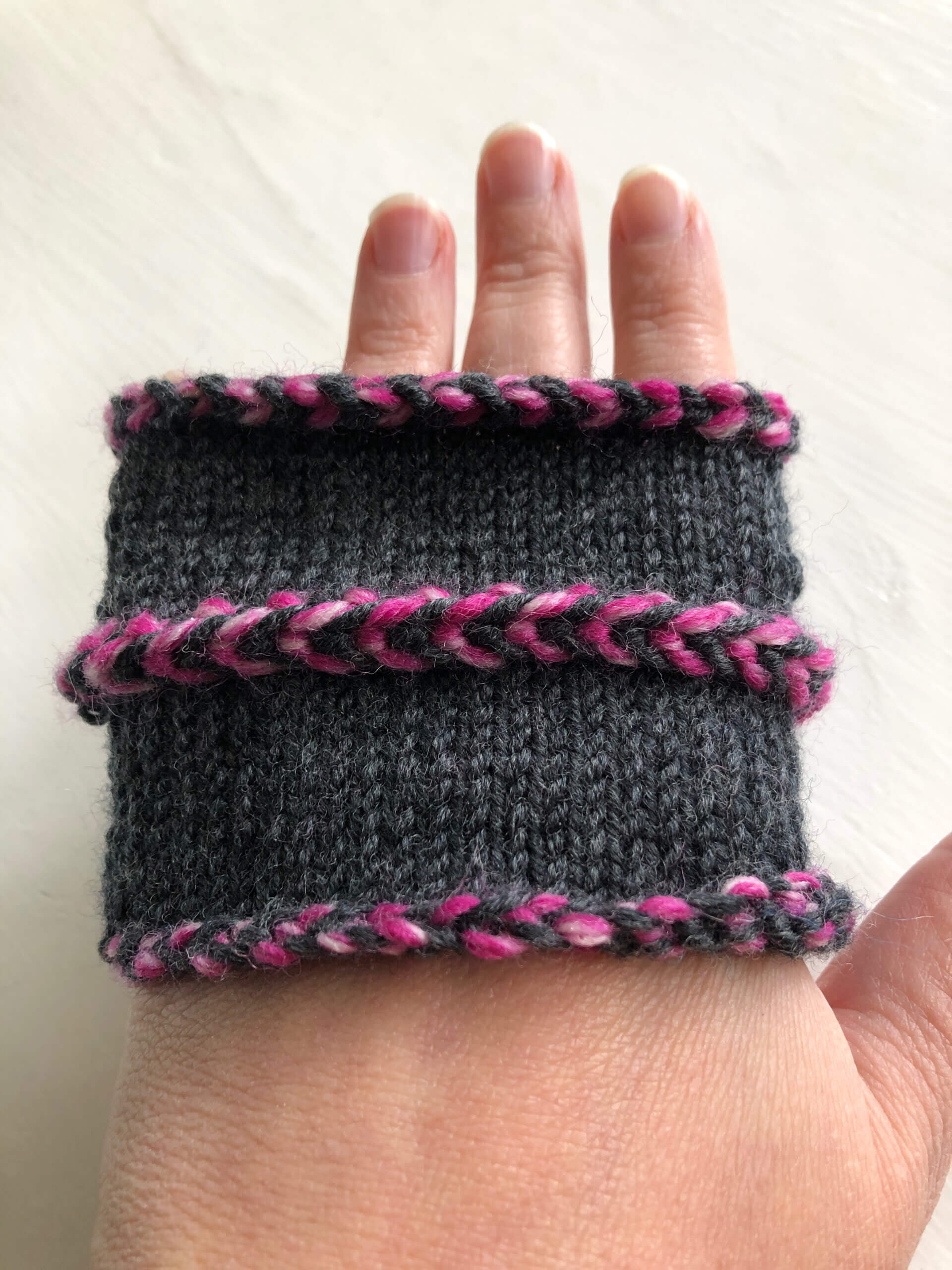 A sample knit in the round showing (from the top down) the Latvian braid bind off, the Latvian braid, and the Latvian cast on 